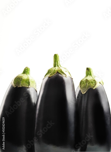 Close up of freshly picked aubergines against clear background photo
