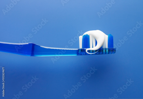 Close up of toothbrush and toothpaste with blue background photo