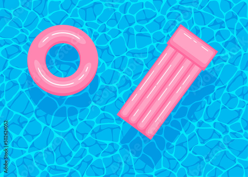 Swimming pool with floating inflatable pink circle and air mattress. Top view