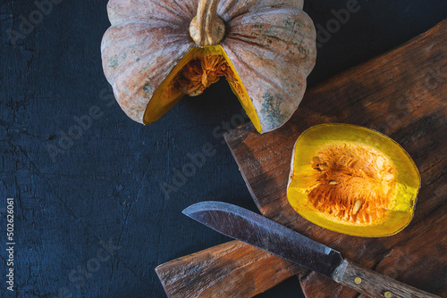 .Vegetable pumpkin cut in half on a wooden cutting board