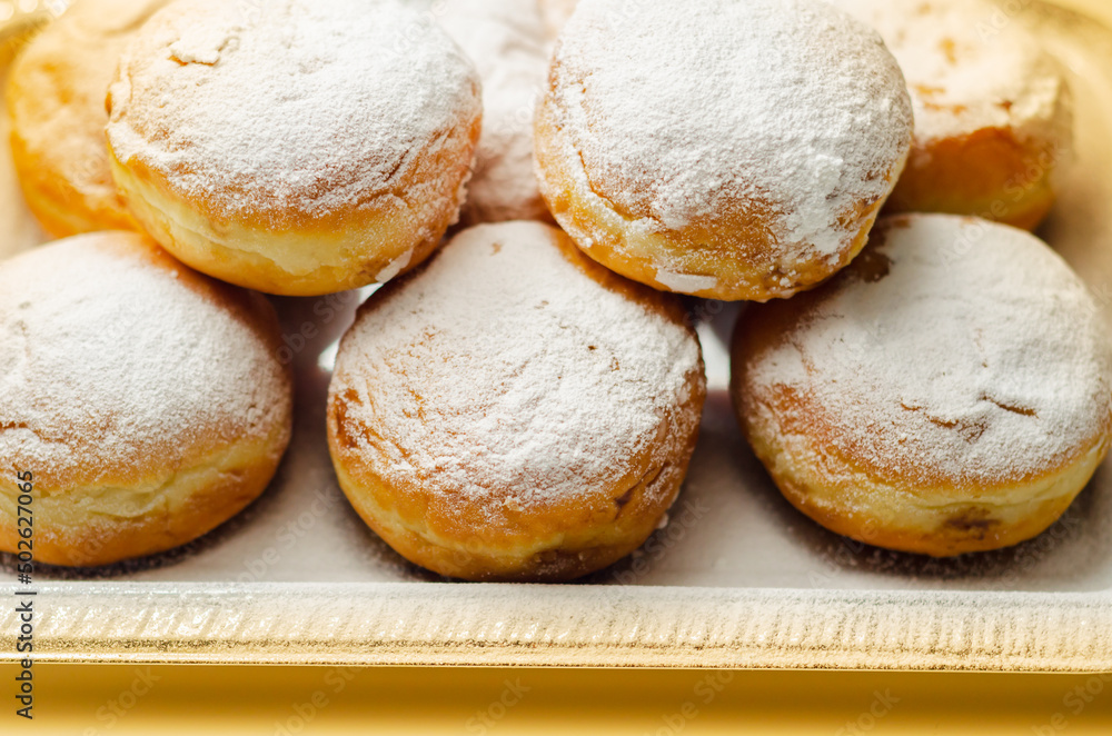 Berliner Pfannkuchen, a German donut, traditional yeast dough deep fried filled with chocolate cream and sprinkled with powdered sugar Berliner Pfannkuchen, a German donut, traditional yeast dough deep fried filled with chocolate cream and sprinkled with powdered sugar