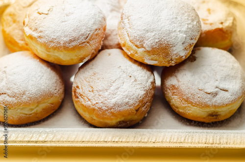 Berliner Pfannkuchen, a German donut, traditional yeast dough deep fried filled with chocolate cream and sprinkled with powdered sugar