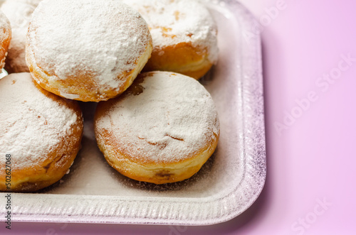 Berliner Pfannkuchen, a German donut, traditional yeast dough deep fried filled with chocolate cream and sprinkled with powdered sugar photo