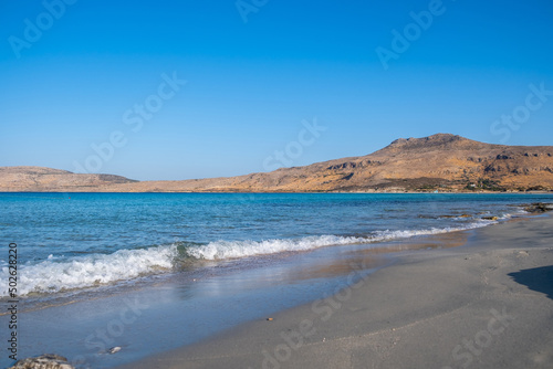 Empty sandy rocky beach, Greece. Elafonisos, island. Sea water turquoise color, sunny summer day