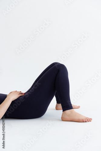 Sporty young woman doing relaxing yoga practice isolated on white background. Concept of healthy life and natural balance between body and mental development. Full length