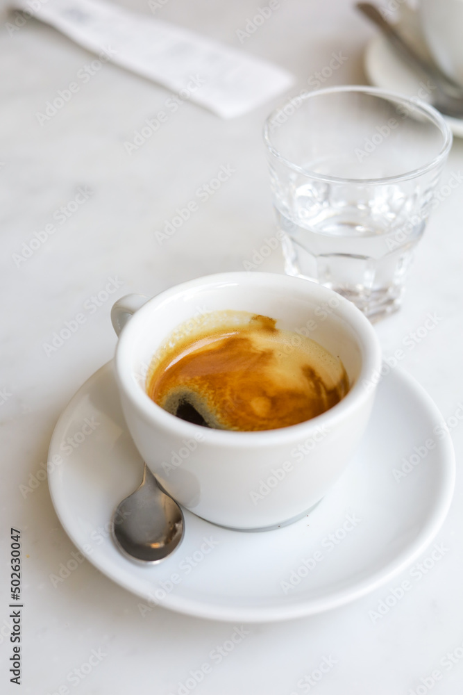 A cup of espresso and a glass of water after coffee. A cup of espresso and a glass of water after coffee.