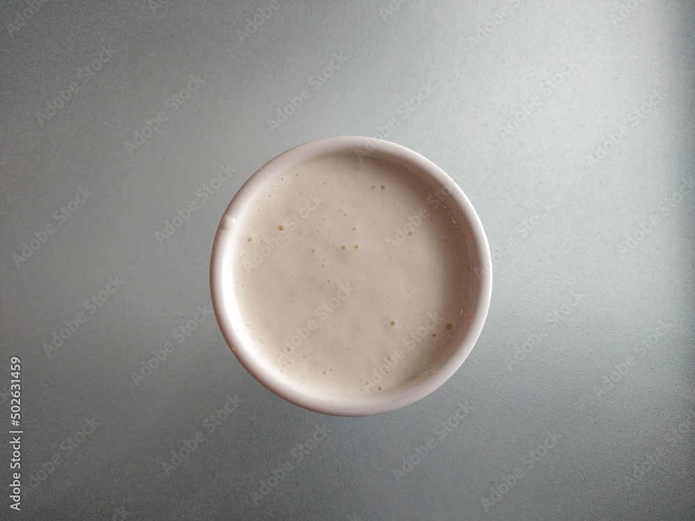Delicious homemade mayonnaise cream sauce in small dip bowl placed on white table background with copyspace. Horizontal closeup macro side view. Delicious homemade mayonnaise cream sauce in small dip bowl placed on white table background with copyspace. Horizontal closeup macro side view.