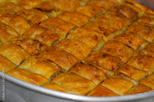 Turkish traditional dessert with pistachio a.k.a. baklava slices serving in the roundel. close up homemade selective focus baklava slices. photo
