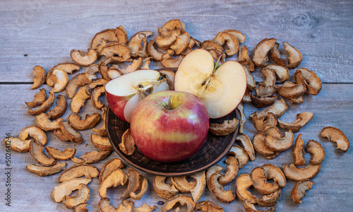 Ripe sliced apple  in a bowl and dried apples on wooden background . Dried fruit chips. Healthy vegan food. Harvesting and drying apples. Dried apple slices on the table.