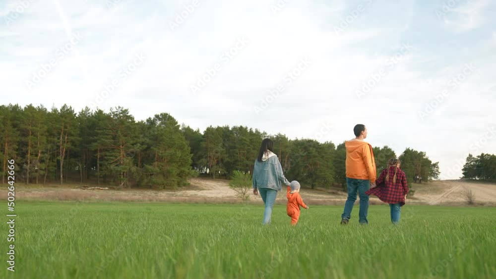 people in the park. happy family a walk at sunset. mom dad and daughter walk holding hands in the park. happy family kid dream concept. parents and life fun baby walking forest park people in the park. happy family a walk at sunset. mom dad and daughter walk holding hands in the park. happy family kid dream concept. parents and life fun baby walking forest park