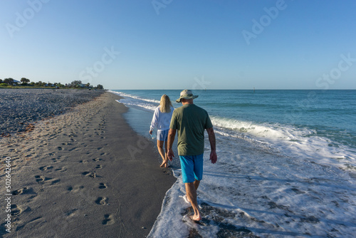 Old folks walk down beach near Tampa, Florida