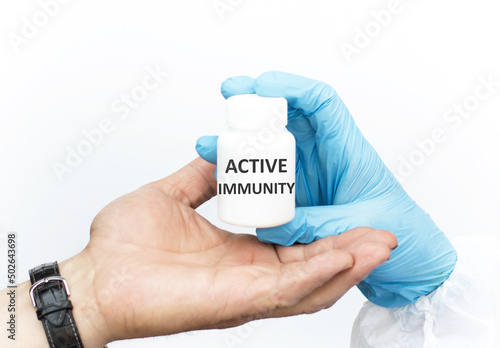 Text Active Immunity on a white jar of medication, the doctor hands over to the recipient
