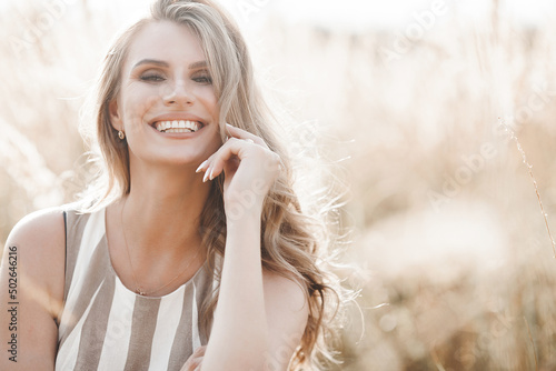 Beautiful blond woman closeup portrait outdoors. Smiling face. Lovely lady at summer background. Emotional female outdoors.