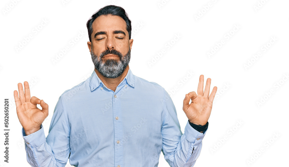 Middle aged man with beard wearing business shirt relaxed and smiling with eyes closed doing meditation gesture with fingers. yoga concept. Middle aged man with beard wearing business shirt relaxed and smiling with eyes closed doing meditation gesture with fingers. yoga concept.