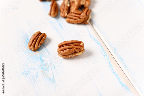 Pecans on a light wooden table.