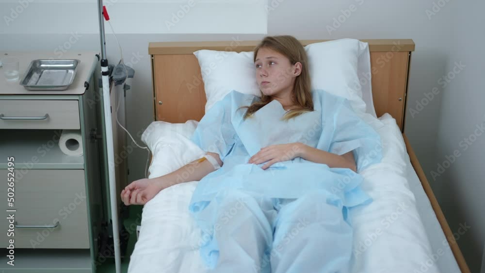 Portrait of depressed teenage Caucasian girl lying in hospital ward with dropper thinking. Sad pretty ill accident victim undergoing treatment in medical clinic. Frustration and sickness concept Portrait of depressed teenage Caucasian girl lying in hospital ward with dropper thinking. Sad pretty ill accident victim undergoing treatment in medical clinic. Frustration and sickness concept