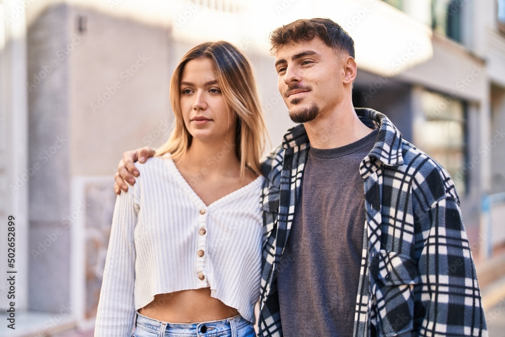 Fototapeta premium Young man and woman couple hugging each other standing at street