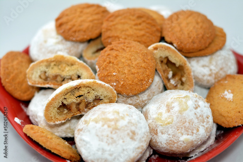 Traditional Arabic cookies for celebration of Islamic holidays of El-Fitr feast, Egyptian Biscuits with shredded coconuts and Kahk covered with powdered sugar and stuffed with hazelnuts and Malban photo