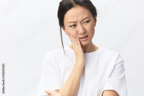 Gumboil Dental abscess Wisdom teeth Periodontitis. Unhappy suffering tanned pretty young Asian woman touch cheek posing isolated on white background. Injuries Poor health Illness concept. Cool offer photo