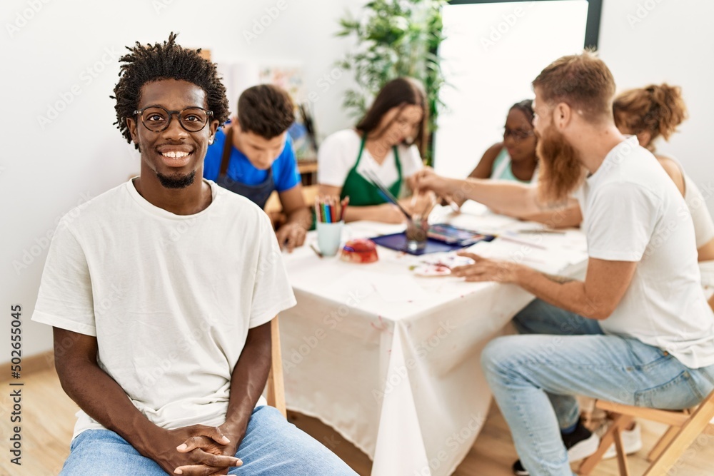 Group of people drawing sitting on the table. African american man smiling happy looking to the camera at art studio. Group of people drawing sitting on the table. African american man smiling happy looking to the camera at art studio.