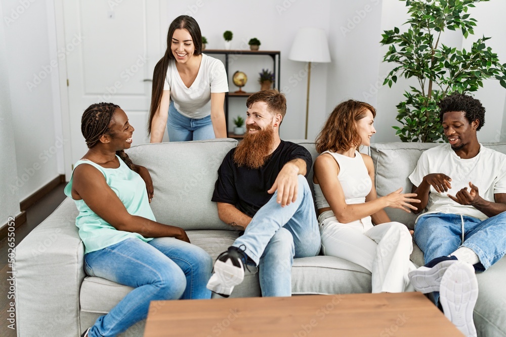 Group of young friends smiling happy sitting on the sofa at home. Group of young friends smiling happy sitting on the sofa at home.