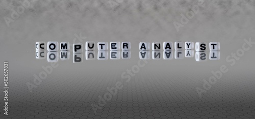 computer analyst word or concept represented by black and white letter cubes on a grey horizon background stretching to infinity