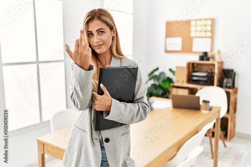 Blonde business woman at the office showing middle finger, impolite and rude fuck off expression © Krakenimages.com