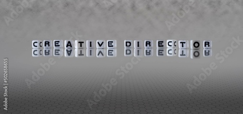 creative director word or concept represented by black and white letter cubes on a grey horizon background stretching to infinity