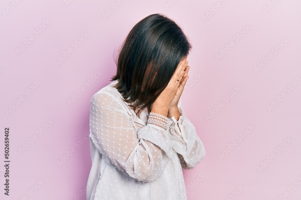 Middle age hispanic woman wearing casual clothes with sad expression covering face with hands while crying. depression concept. Middle age hispanic woman wearing casual clothes with sad expression covering face with hands while crying. depression concept.