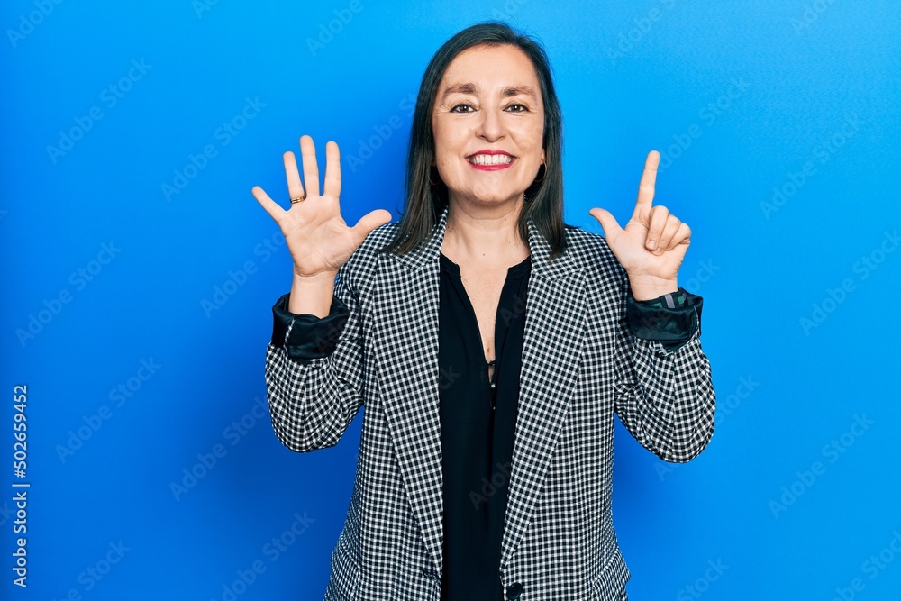 Middle age hispanic woman wearing business clothes showing and pointing up with fingers number seven while smiling confident and happy. Middle age hispanic woman wearing business clothes showing and pointing up with fingers number seven while smiling confident and happy.
