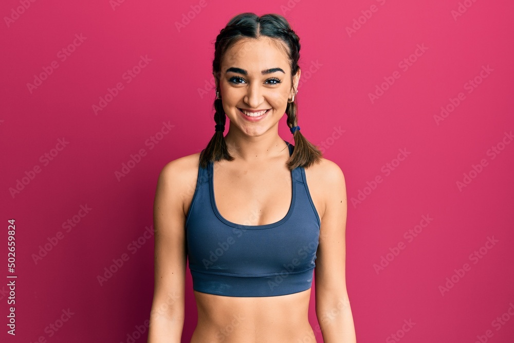 Young brunette girl wearing sportswear and braids with a happy and cool smile on face. lucky person. Young brunette girl wearing sportswear and braids with a happy and cool smile on face. lucky person.