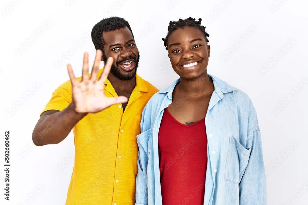 Young african american couple wearing casual clothes showing and pointing up with fingers number five while smiling confident and happy. Young african american couple wearing casual clothes showing and pointing up with fingers number five while smiling confident and happy.