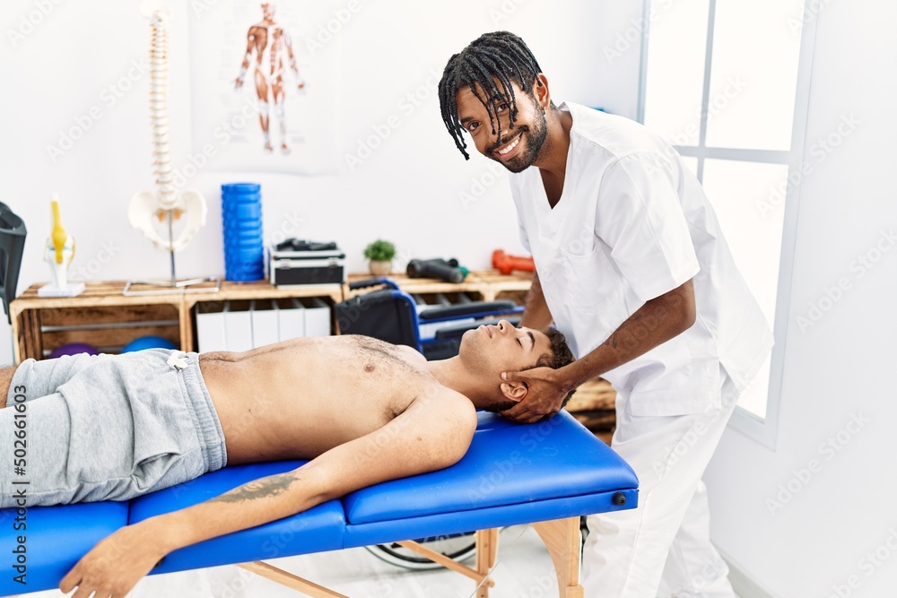 Obraz premium Two men physiptherapist and patient having rehab session massaging neck at clinic