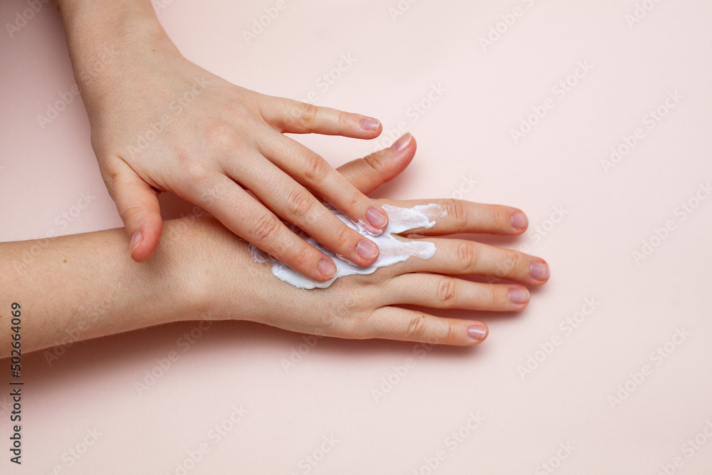 Fototapeta premium cream on hand on pink background