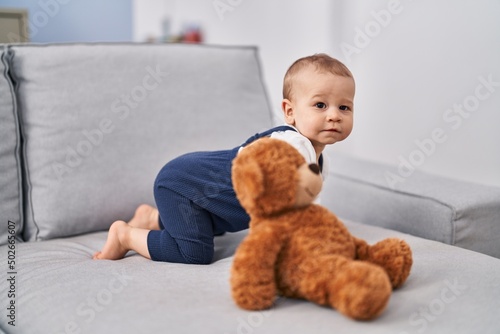 Adorable toddler crowling on sofa at home photo