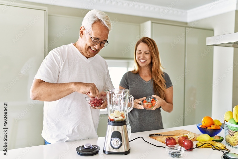 Middle age hispanic couple smiling happy cooking smoothie at the kitchen. Middle age hispanic couple smiling happy cooking smoothie at the kitchen.