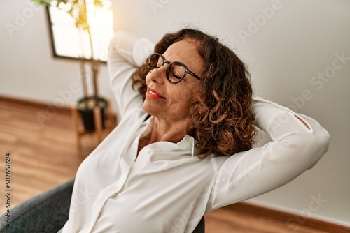 Middle age hispanic woman smiling confident relaxing at office