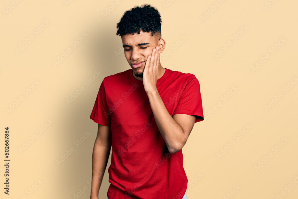 Young african american man wearing casual red t shirt touching mouth with hand with painful expression because of toothache or dental illness on teeth. dentist Young african american man wearing casual red t shirt touching mouth with hand with painful expression because of toothache or dental illness on teeth. dentist