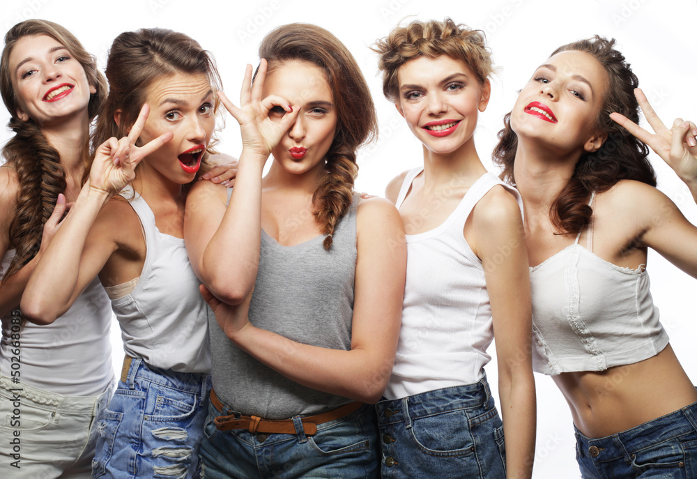 Group of five women friends laughing and looking at camera over white background Group of five women friends laughing and looking at camera over white background