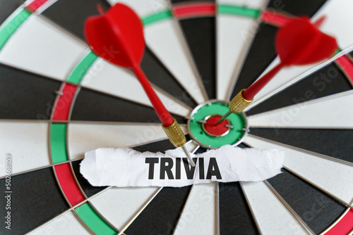 The picture shows a target, darts and a torn piece of paper with the inscription - TRIVIA