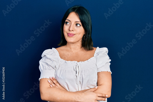 Young hispanic woman wearing casual clothes smiling looking to the side and staring away thinking.
