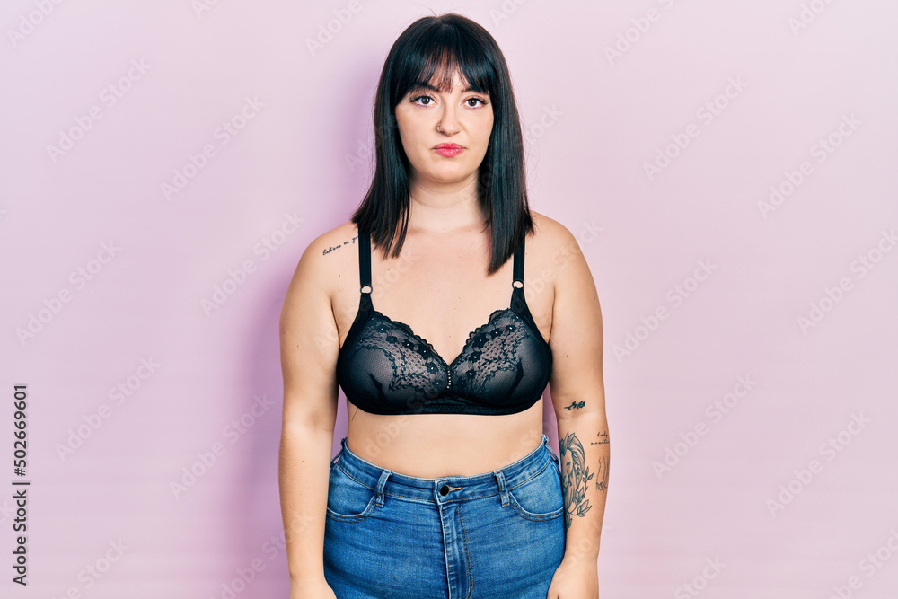 Young hispanic woman wearing lingerie with serious expression on face. simple and natural looking at the camera. Young hispanic woman wearing lingerie with serious expression on face. simple and natural looking at the camera.