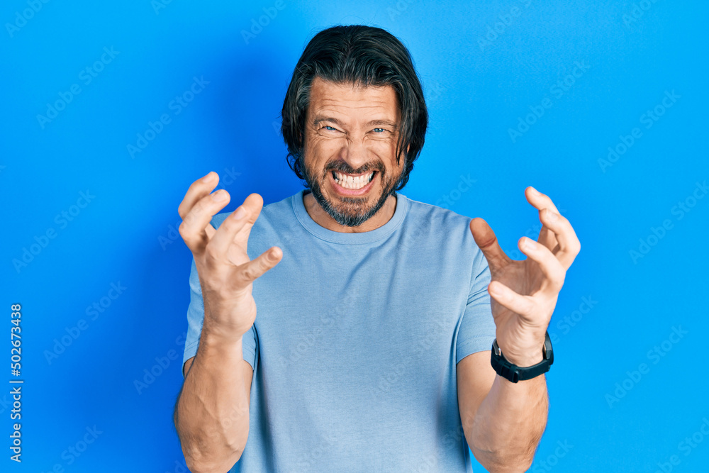 Middle age caucasian man wearing casual clothes shouting frustrated with rage, hands trying to strangle, yelling mad Middle age caucasian man wearing casual clothes shouting frustrated with rage, hands trying to strangle, yelling mad
