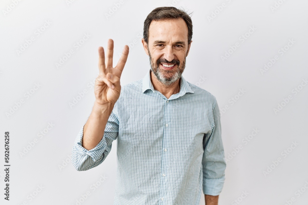 Middle age hispanic man with beard standing over isolated background showing and pointing up with fingers number three while smiling confident and happy. Middle age hispanic man with beard standing over isolated background showing and pointing up with fingers number three while smiling confident and happy.