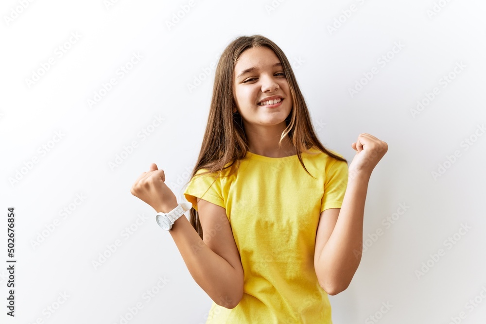 Young brunette teenager standing together over isolated background celebrating surprised and amazed for success with arms raised and eyes closed. winner concept. Young brunette teenager standing together over isolated background celebrating surprised and amazed for success with arms raised and eyes closed. winner concept.