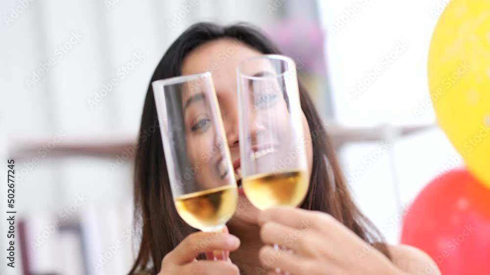 Two Asian women drink champagne and dance at a party Two Asian women drink champagne and dance at a party