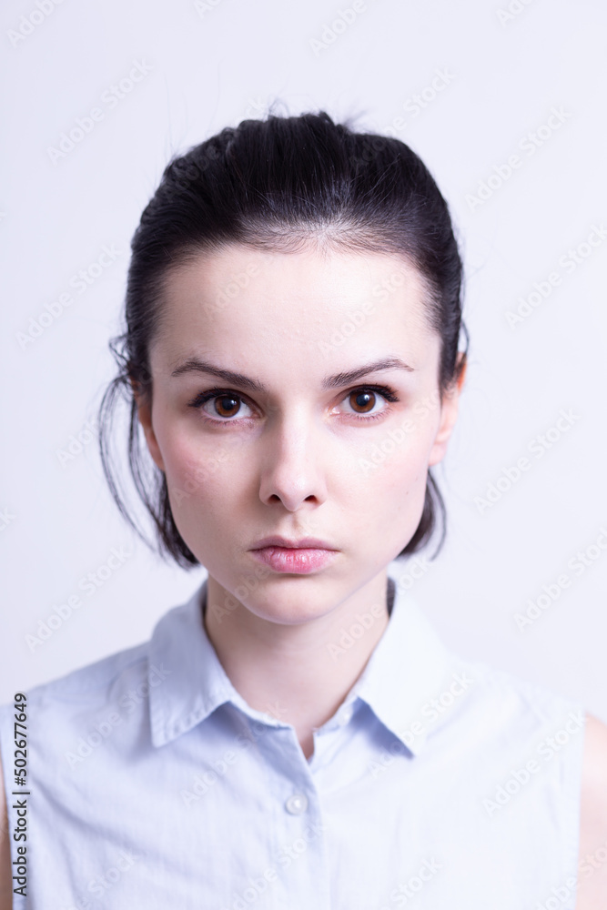 woman in a blue sleeveless office shirt, light background