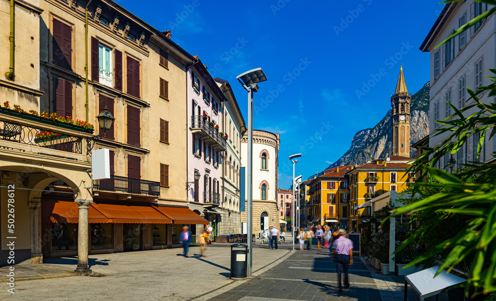 View of old town streets of Italian city of Lecco on background of San Martino mountain at sunny day