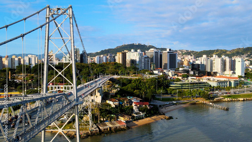 aerial drone image of suspension bridge connecting cities urban centers Ponte Hercílio Luz Florianópolis Santa Catarin cable-stayed bridge #502679020