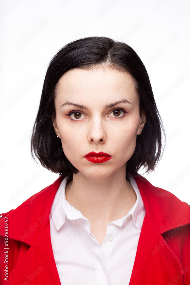 brunette woman with red lipstick on her lips in a red jacket and white shirt, white background brunette woman with red lipstick on her lips in a red jacket and white shirt, white background